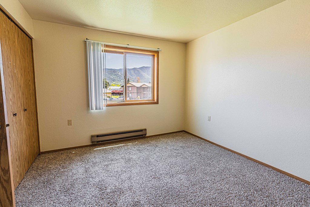 an empty room with a window and a gravel floor