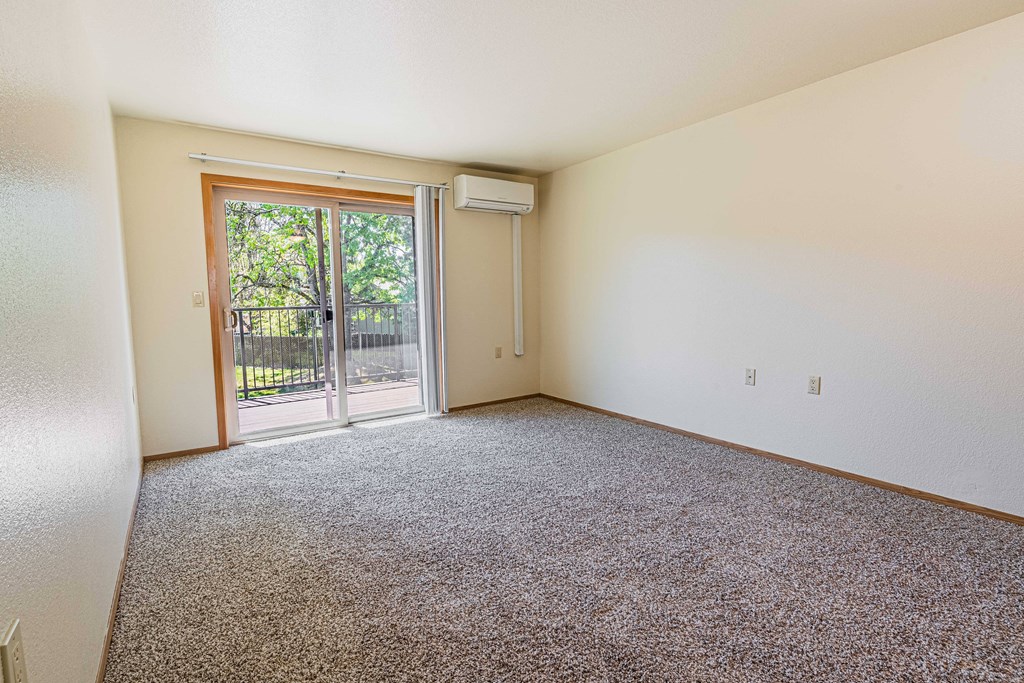 a room with carpet and a door to a patio