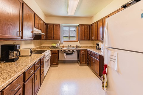 a kitchen with wooden cabinets and granite counter tops and a refrigerator