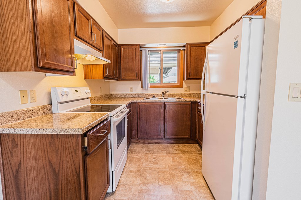 a kitchen with wooden cabinets and a white refrigerator