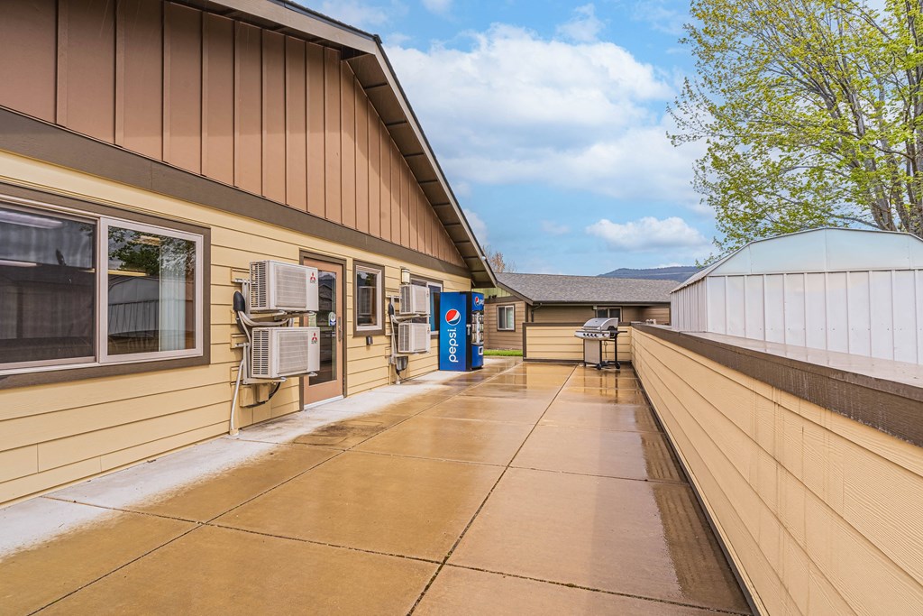 the entrance to a building with a patio and air conditioning units on the side