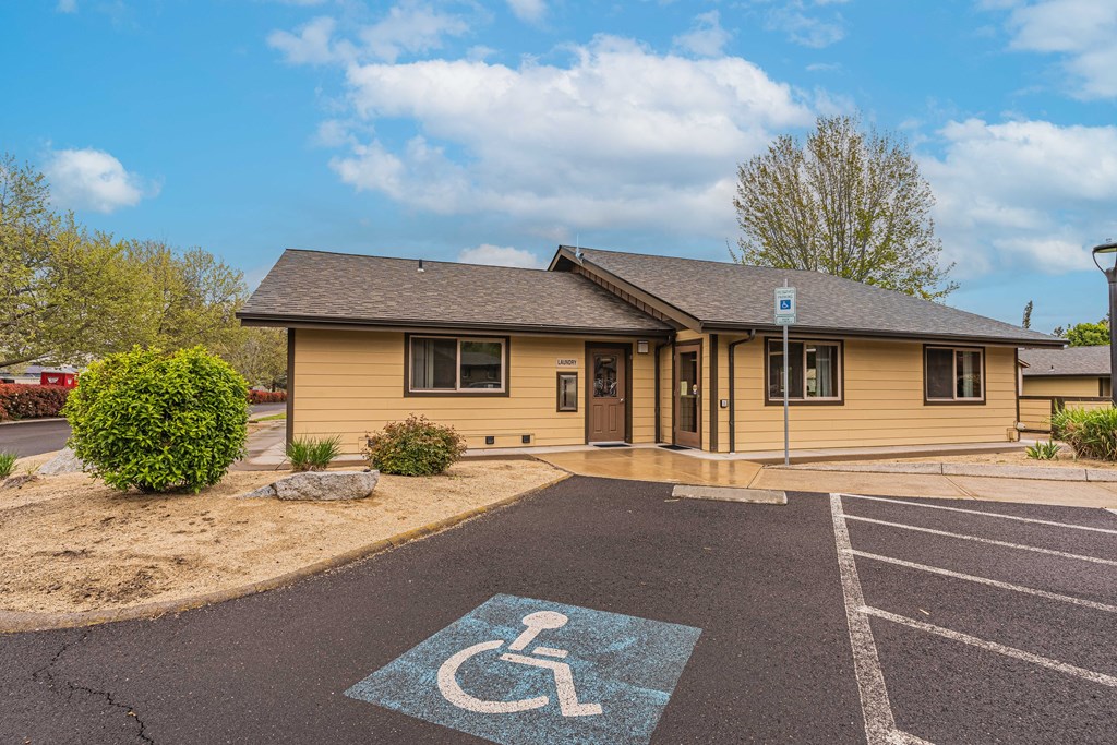 a handicapped accessible parking lot in front of a yellow building