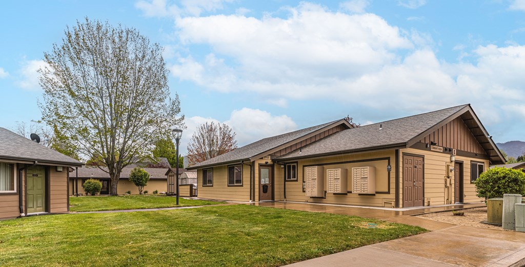 a group of houses in a row with grass and a sidewalk