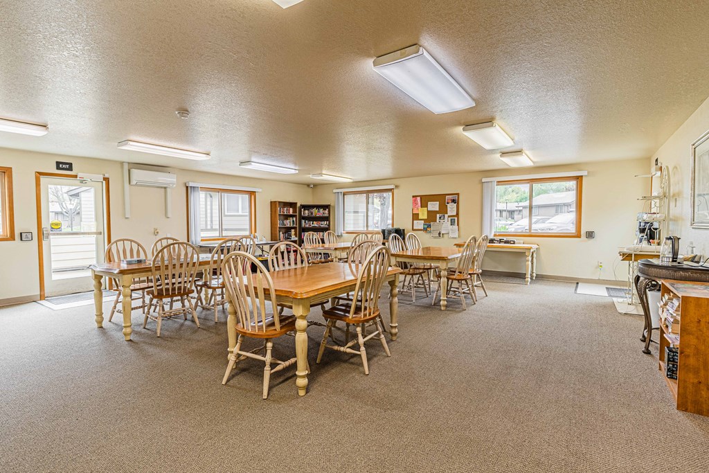 a large room with tables and chairs and a kitchen