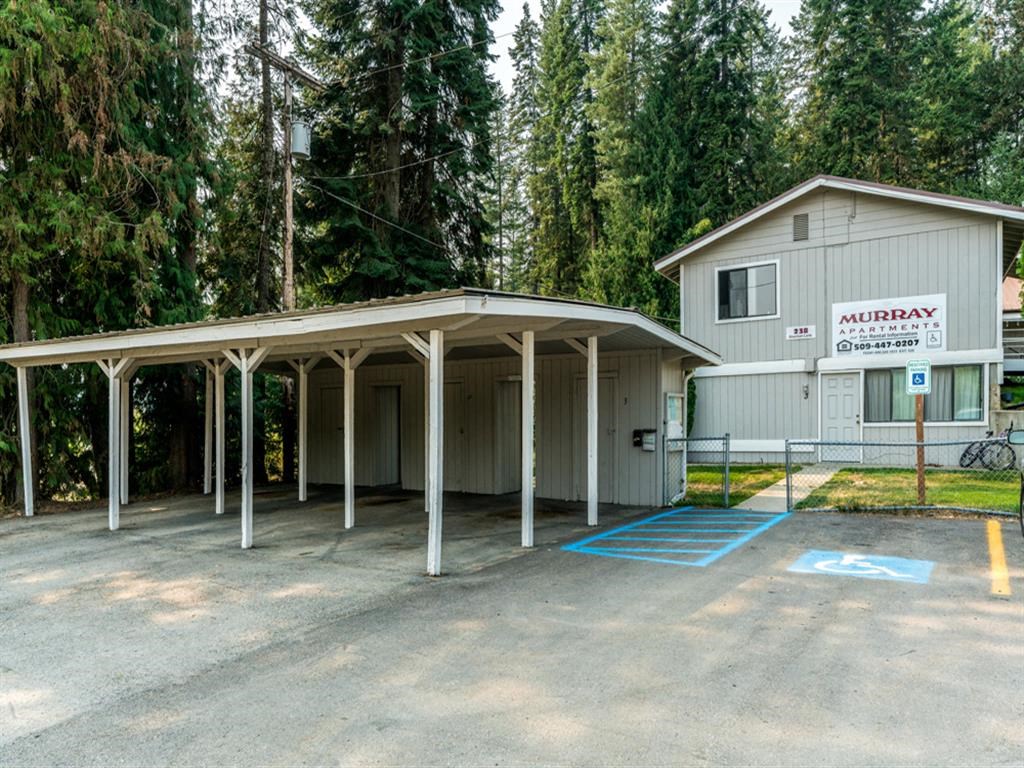 a covered parking lot in front of a car garage