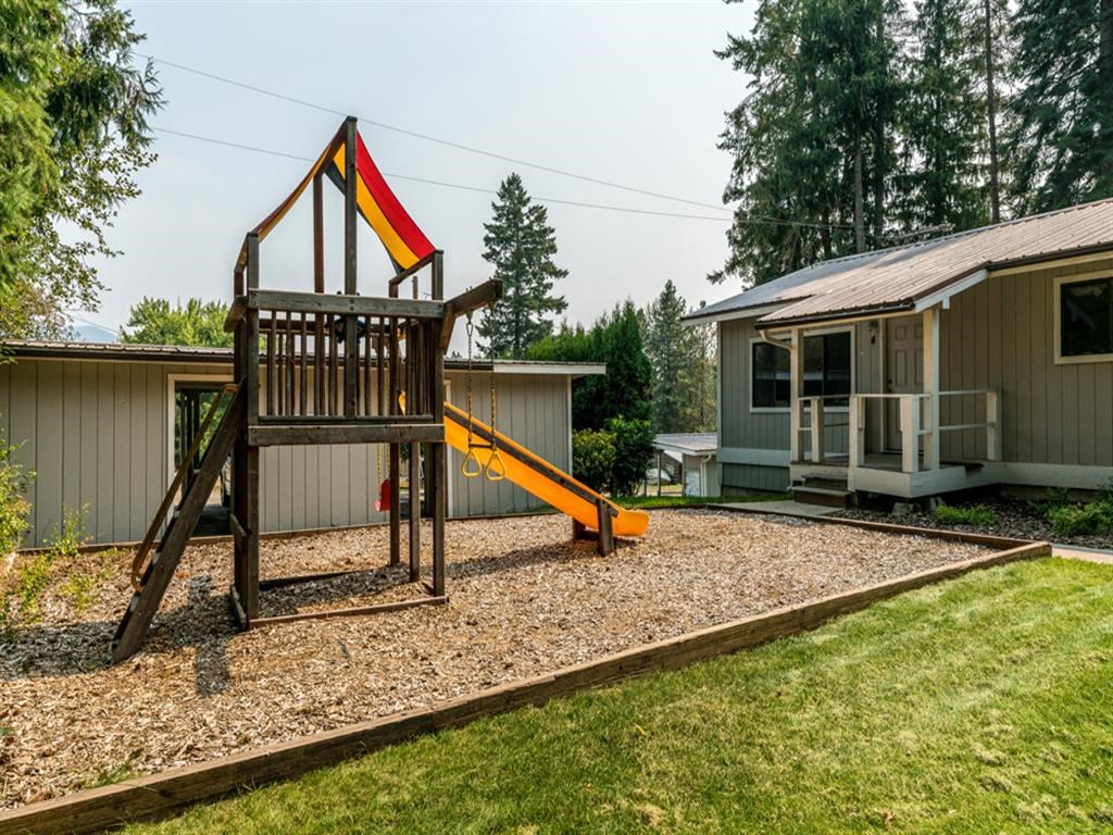 a swing set in a backyard next to a house