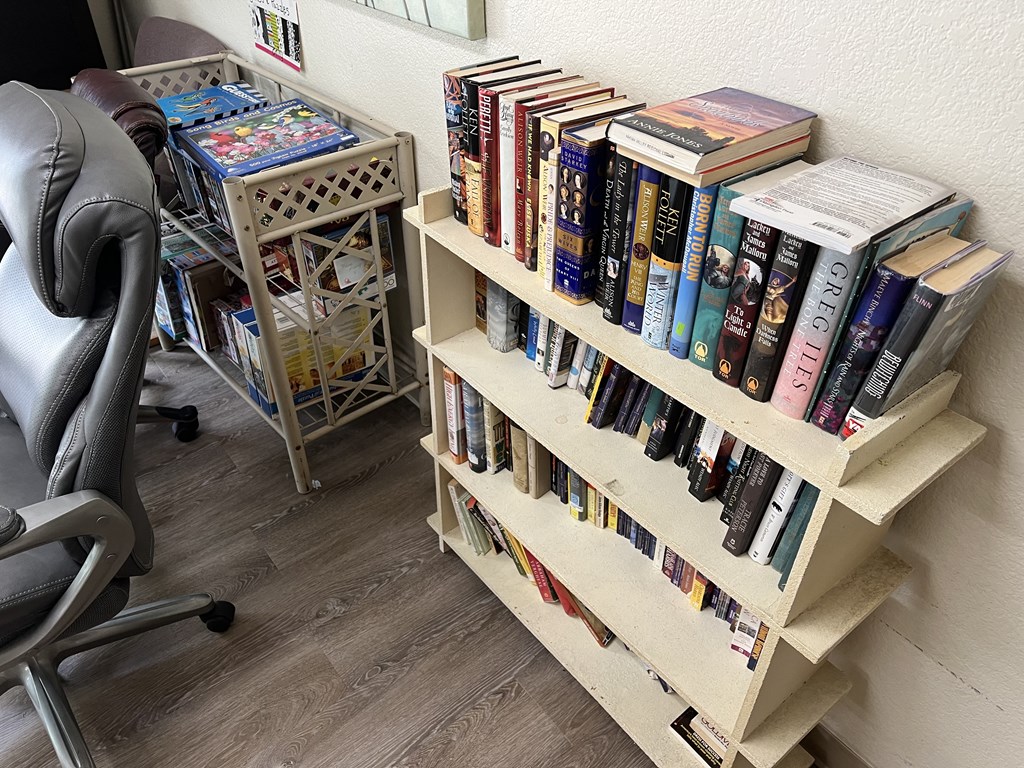 a book shelf filled with books and a chair in a room