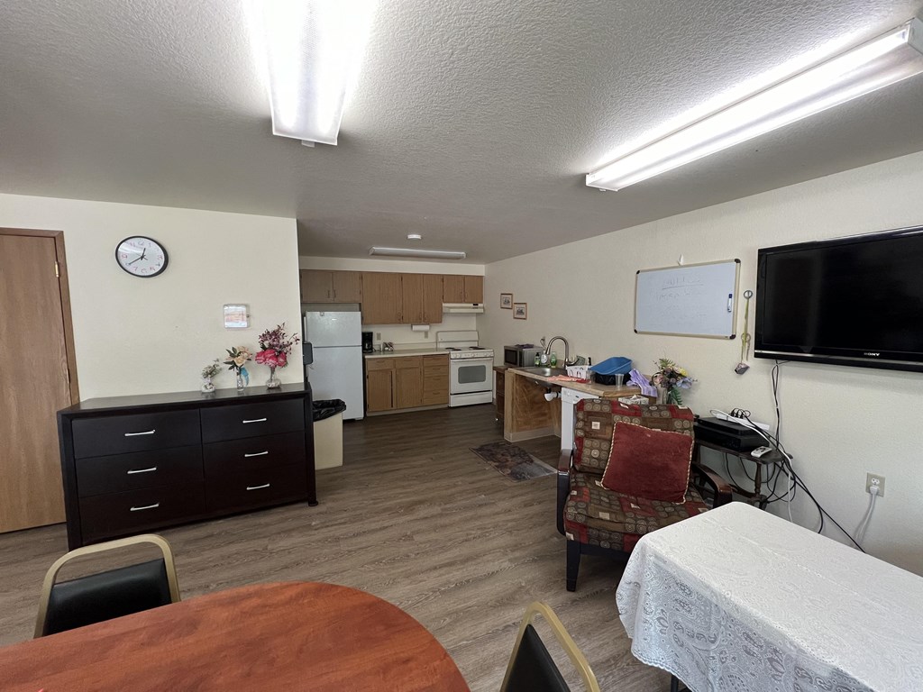 a kitchen and living room with a table and a chair