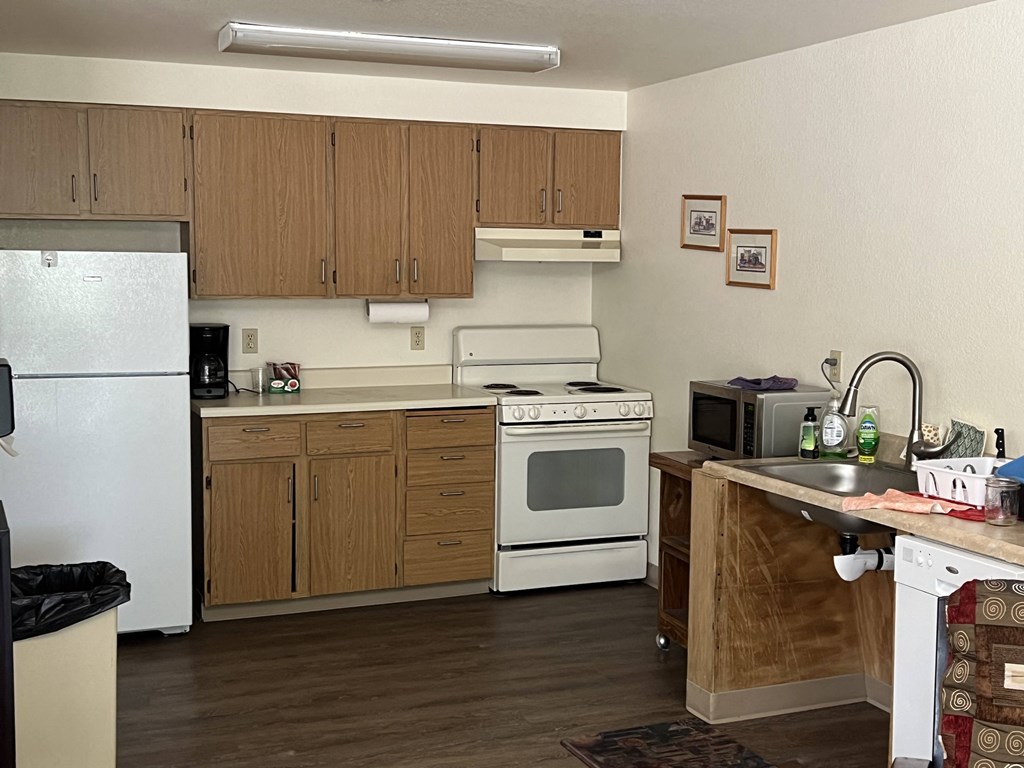 a kitchen with white appliances and wooden cabinets