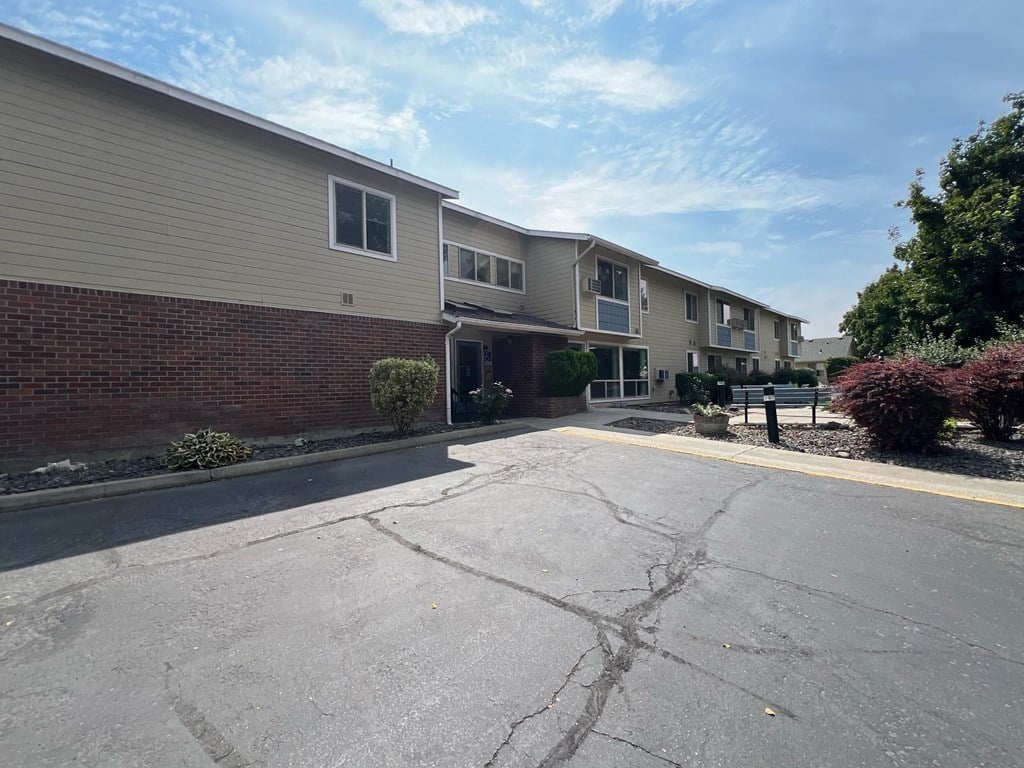 an empty parking lot in front of an apartment building