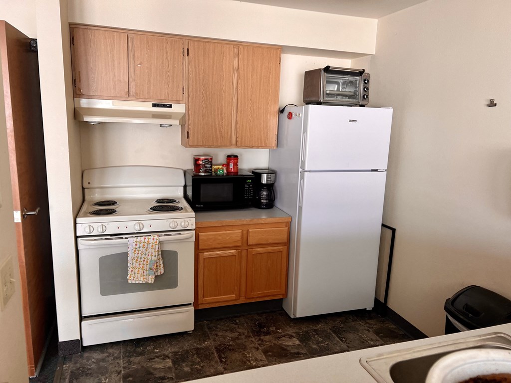 a kitchen with a stove refrigerator and microwave