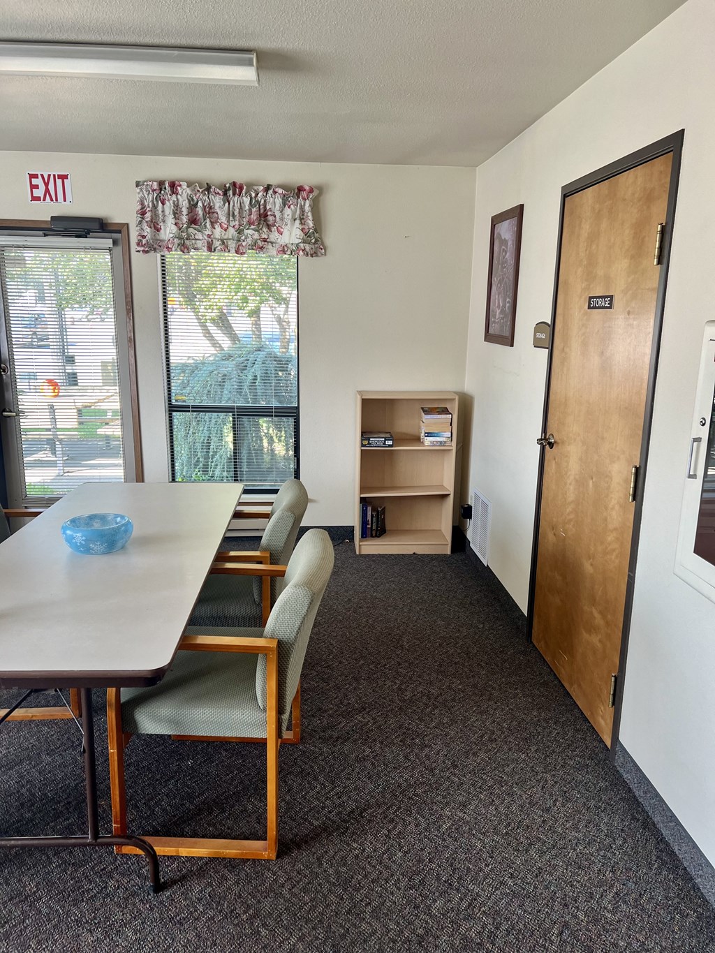 a conference room with a table and chairs and a exit door