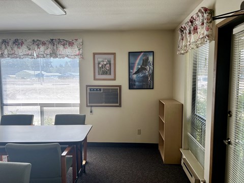a dining room with a table and chairs and a window
