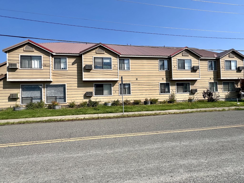 a building with a red roof on the side of a street
