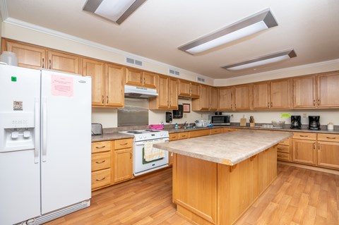 A kitchen with wooden cabinets and a white fridge.