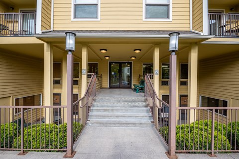 A building with a yellow facade and a staircase leading to the entrance.