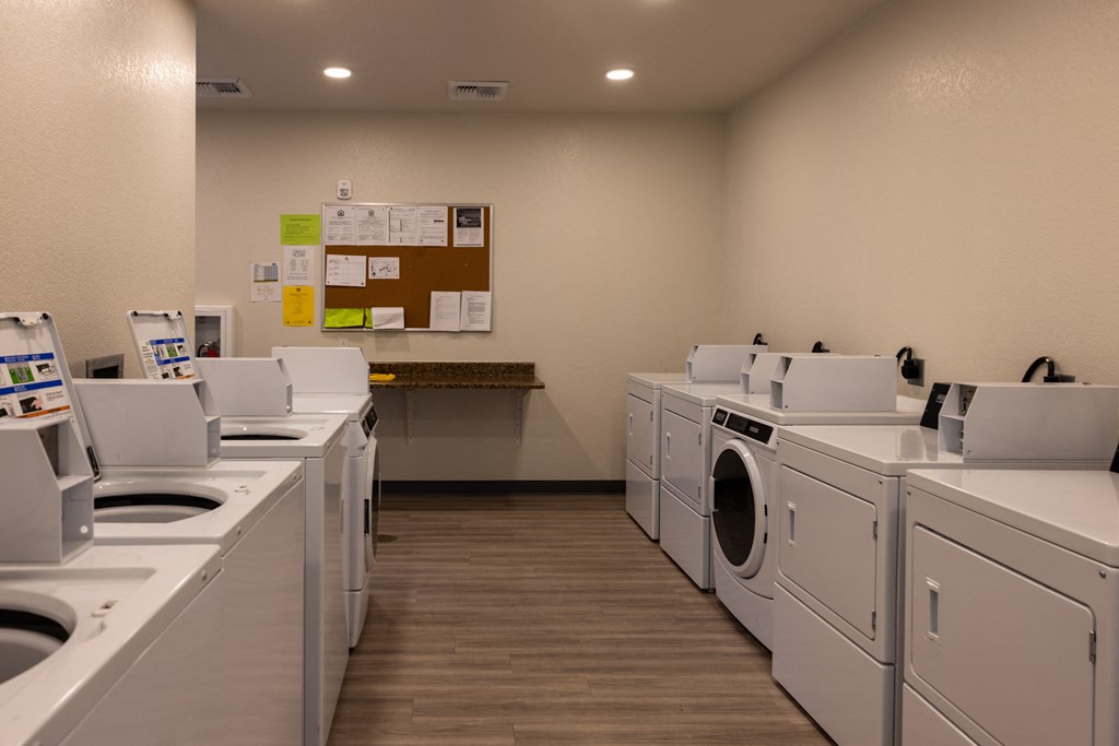 a row of washers and dryers in a laundromat with many machines
