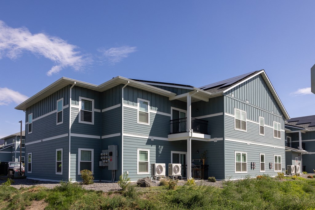 A blue house with a white roof and a balcony.