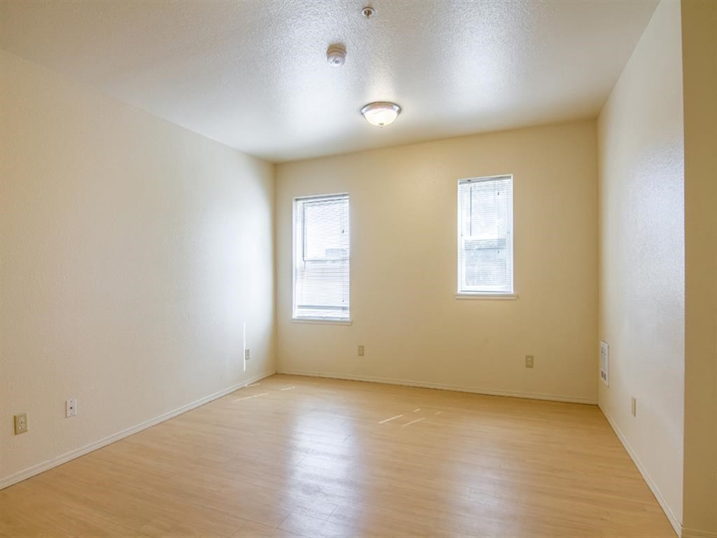 the living room of an empty house with a wooden floor