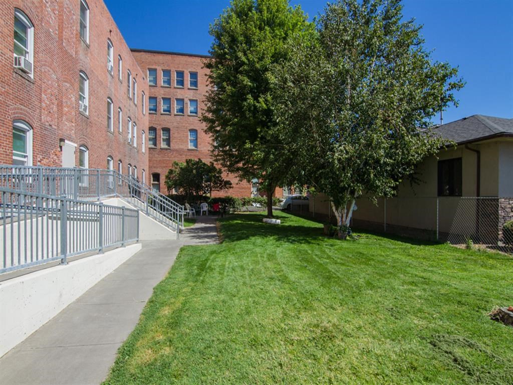 a sidewalk in front of a brick building