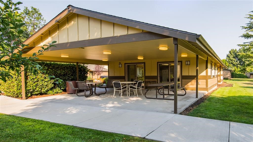 a covered patio with a table and chairs