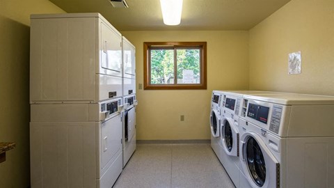 a laundry room with washes and dryers and a window