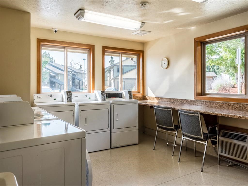 a laundry room with washers and a counter with chairs