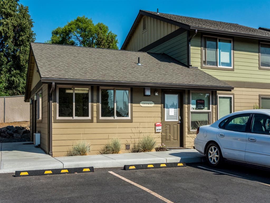 a tan building with a car parked in front of it
