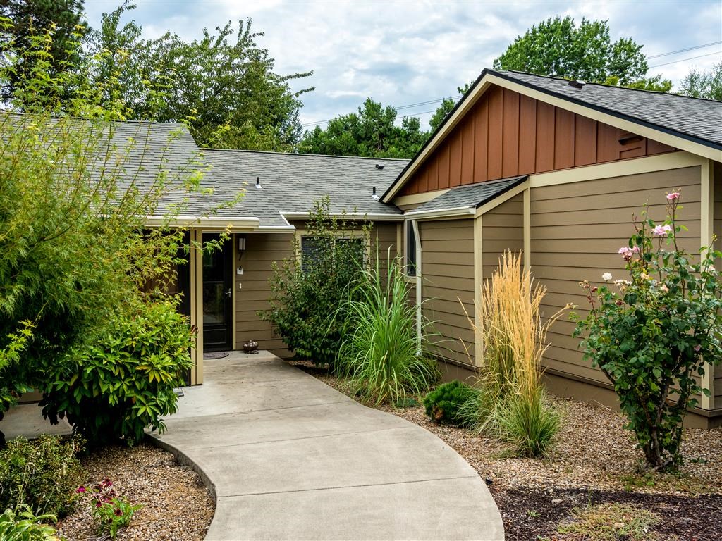a small house with a sidewalk in front of it