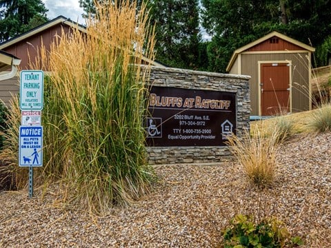 a sign in front of a building with tall grass