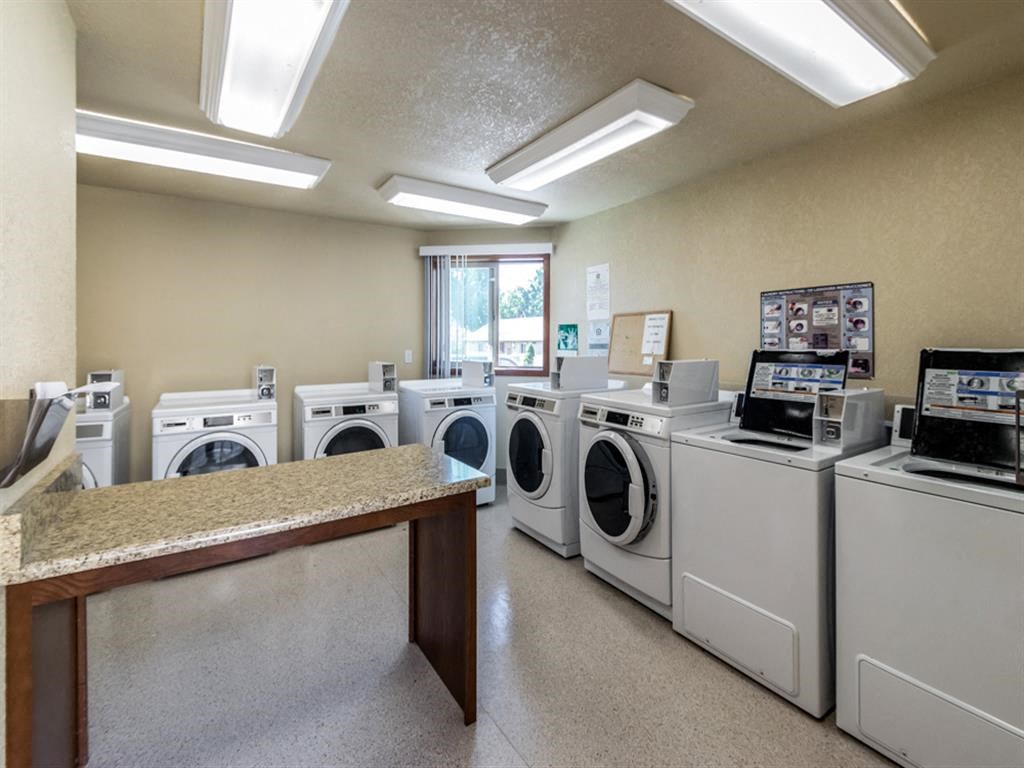 a laundry room filled with washers and dryers in a laundromat