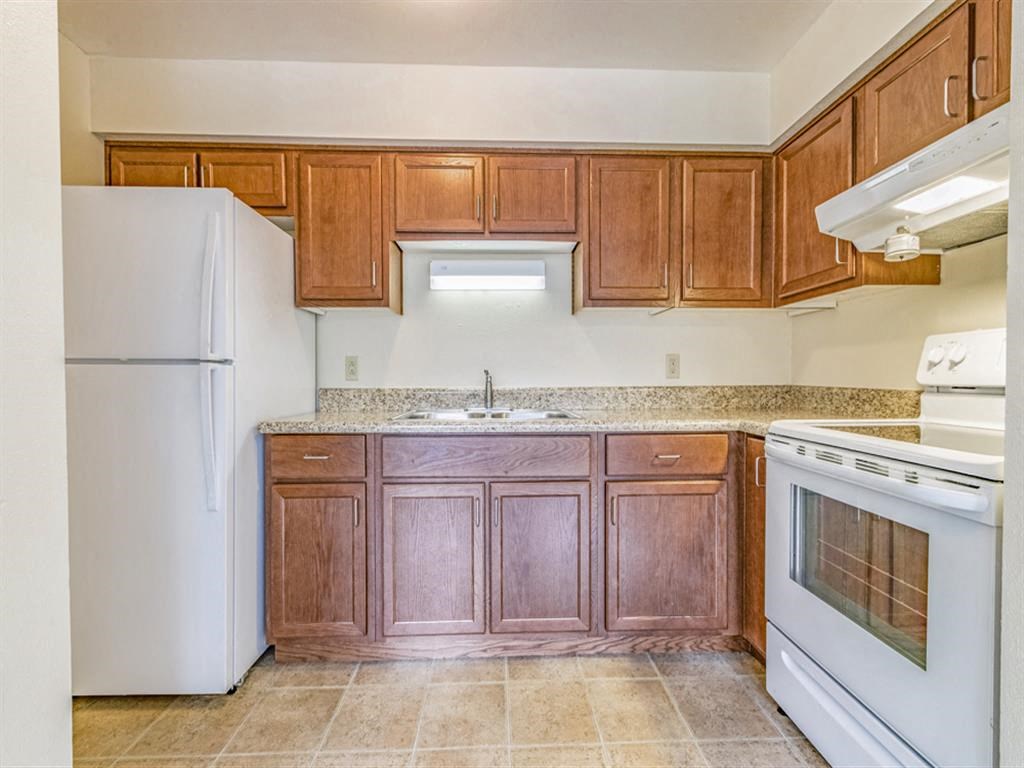 a kitchen with wooden cabinets and white appliances