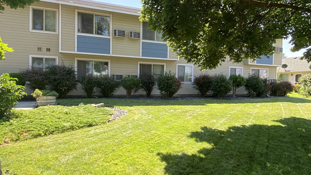 an apartment building with a large lawn in front of it
