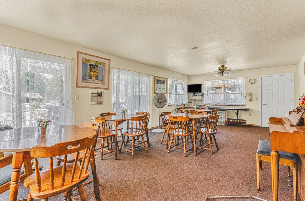 a dining room with tables and chairs and a kitchen