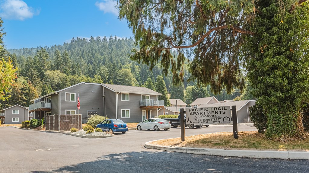 a building with a sign in front of it and trees