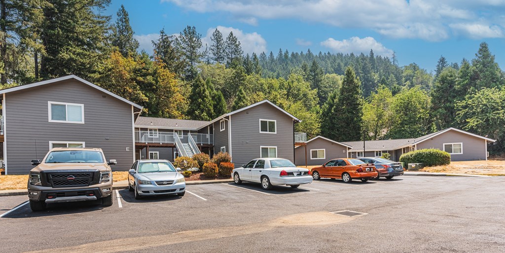 a parking lot filled with cars in front of houses