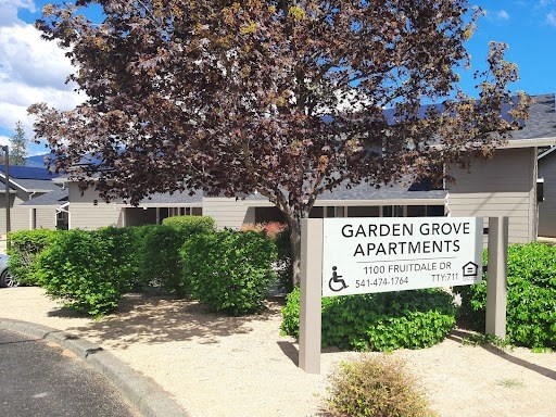 a sign in front of a building that says garden grove apartments