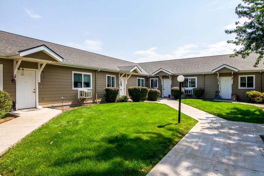 a sidewalk in front of a row of houses