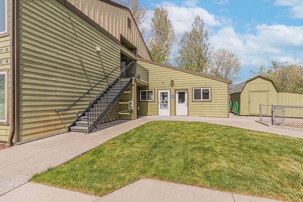 the front of a house with a yard and a building