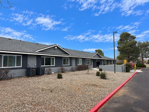 A grey building with a red curb in front.