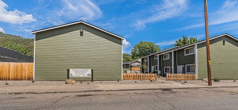 a green building with a sign in front of it on a street