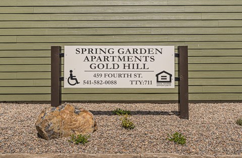 a sign for the spring garden apartments gold hill