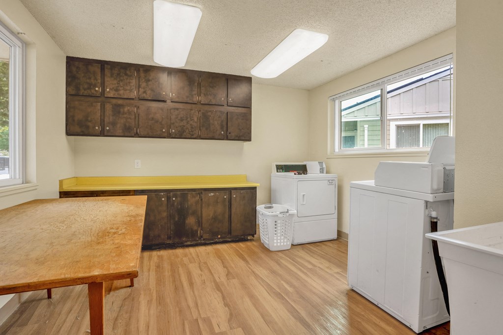 an empty kitchen with a table and a washer and dryer
