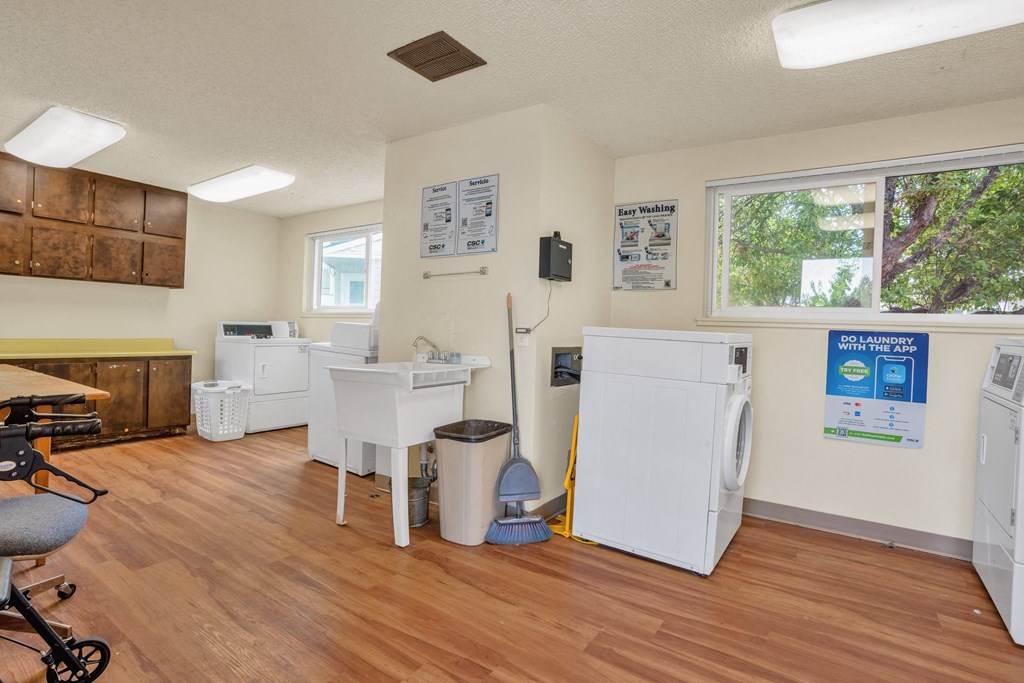 a kitchen with two refrigerators and a sink in a room with a wood floor