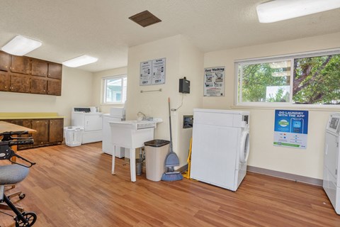a kitchen with two refrigerators and a sink in a room with a wood floor
