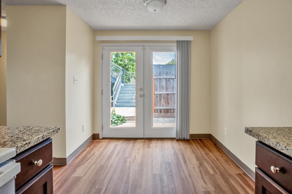 an empty living room with sliding glass doors to a balcony