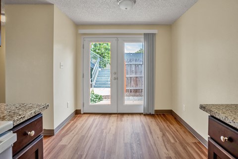 an empty living room with sliding glass doors to a balcony