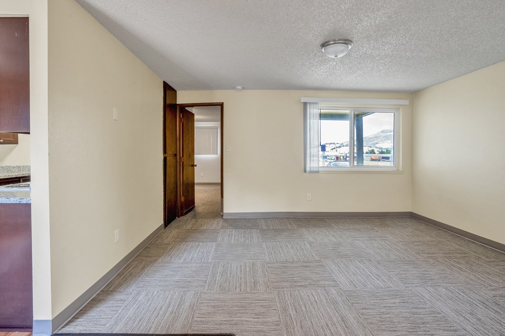 the living room and dining room of an empty house with a window