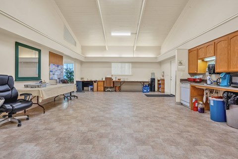 a large room with a kitchen and a table with a chair