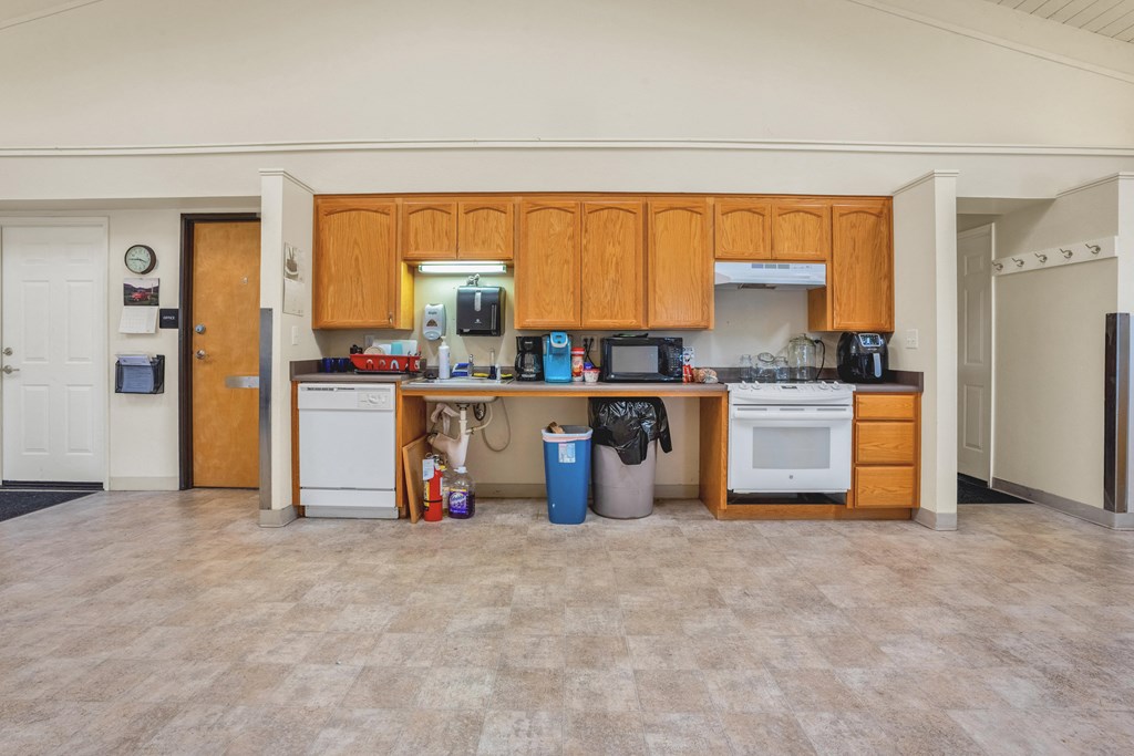 a kitchen with wood cabinets and a white stove and a sink